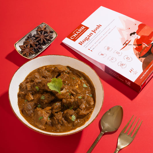 Bowl of Rogan Josh curry with a box labeled 'CHAAR Rogan Josh' on a red background